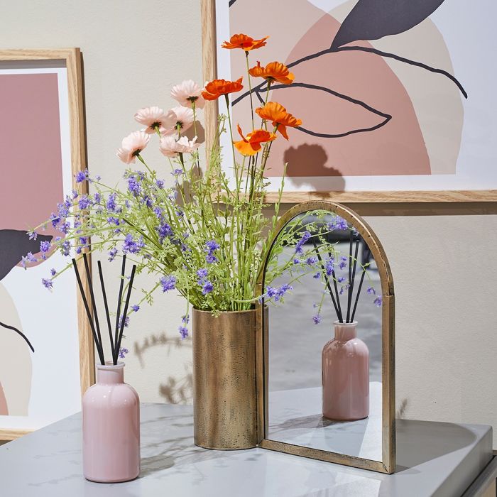 Duftpinde pretty woman i lyserød flaske med en buket blomster i vase