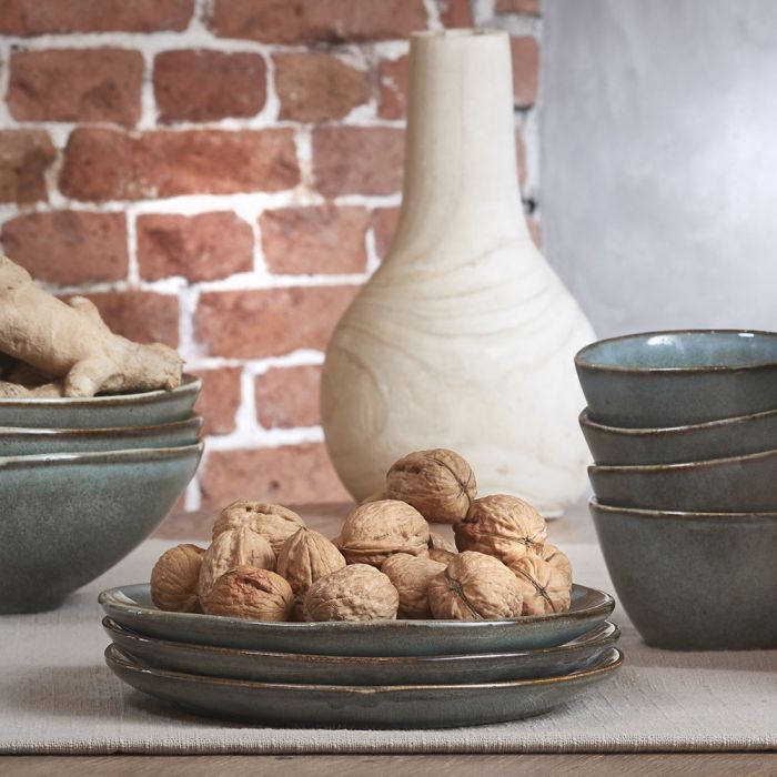 Tabo frokosttallerkener i grøn stentøj stablet med valnødder