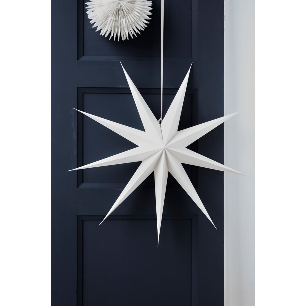 Large white 9-point star from House Doctor displayed in front of a blue door
