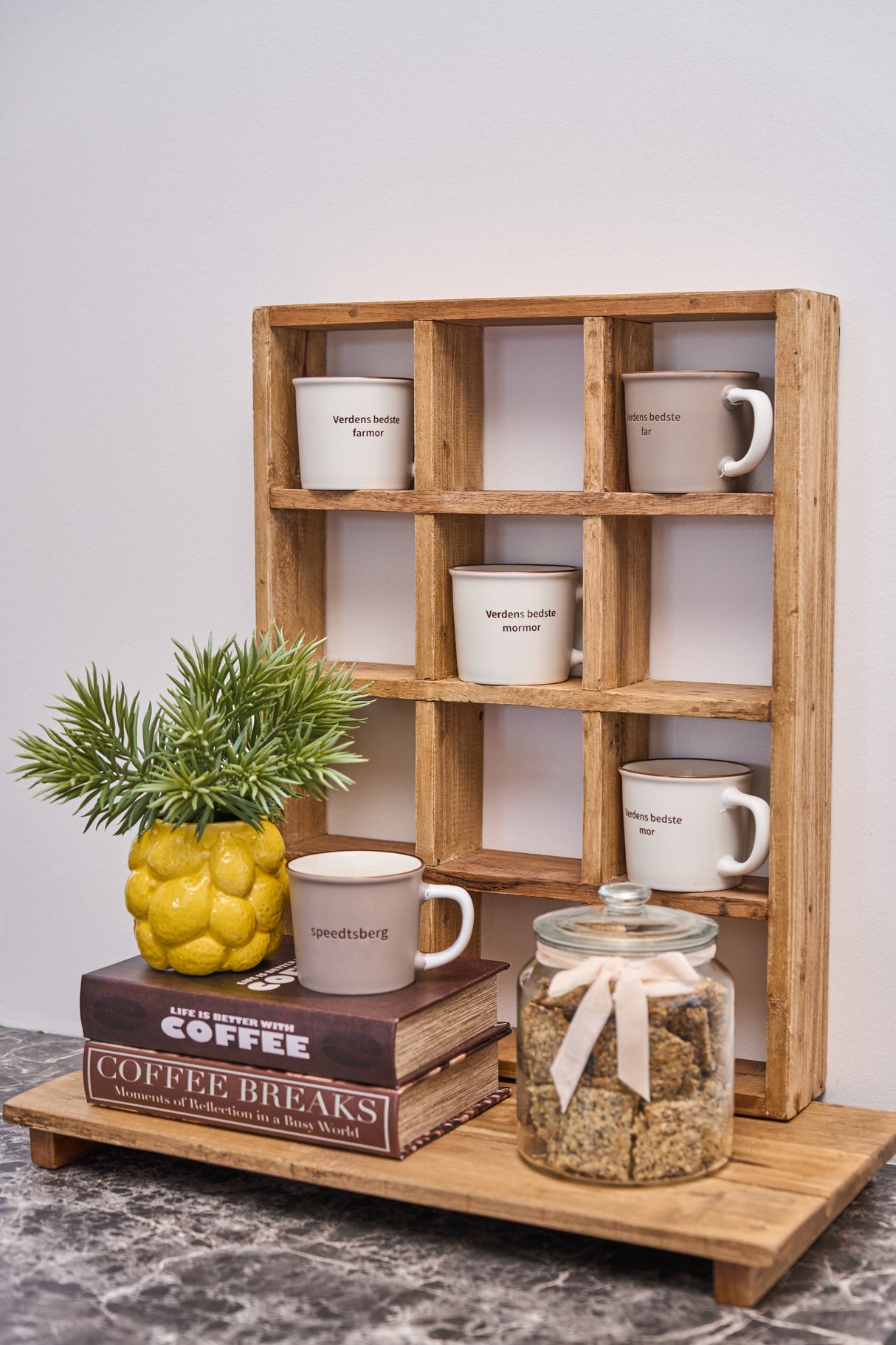 Køkkenreol med små rum, hvor der står kopper