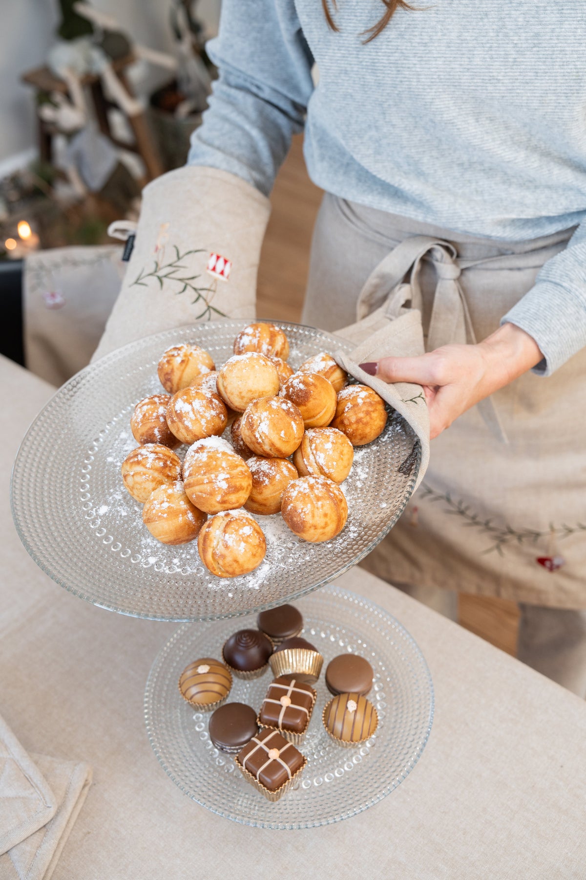 Warm Danish pancake balls (æbleskiver) set on the table with a quilted cotton grill glove and potholder.