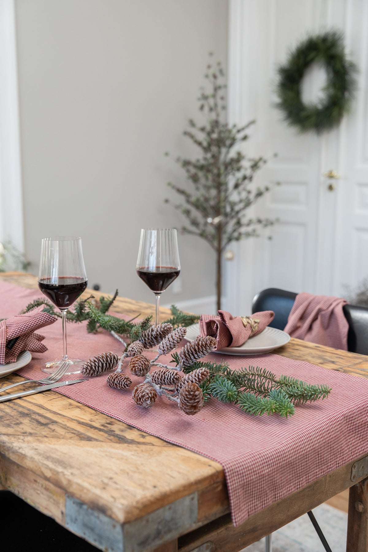 Artificial pine-cone branches arranged as table decoration on the Christmas table