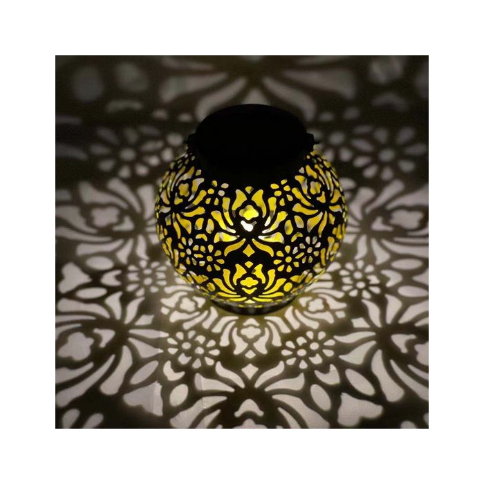 Solcellelampe i sort metal med blomster, som kaster smukt lys ud.
