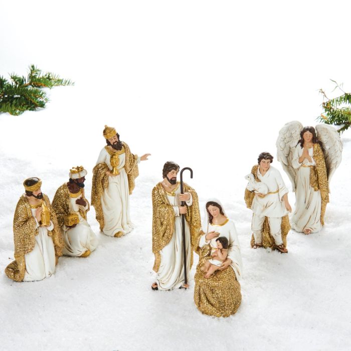 Krybbespilsfigurer i guld og hvide farver. Josef betragter Jomfru Maria og Jesusbarnet, sammen med de 3 visemænd, en hyrde og en engel. Figurerne er adskilte og dermed flytbare. Fra Pobra.