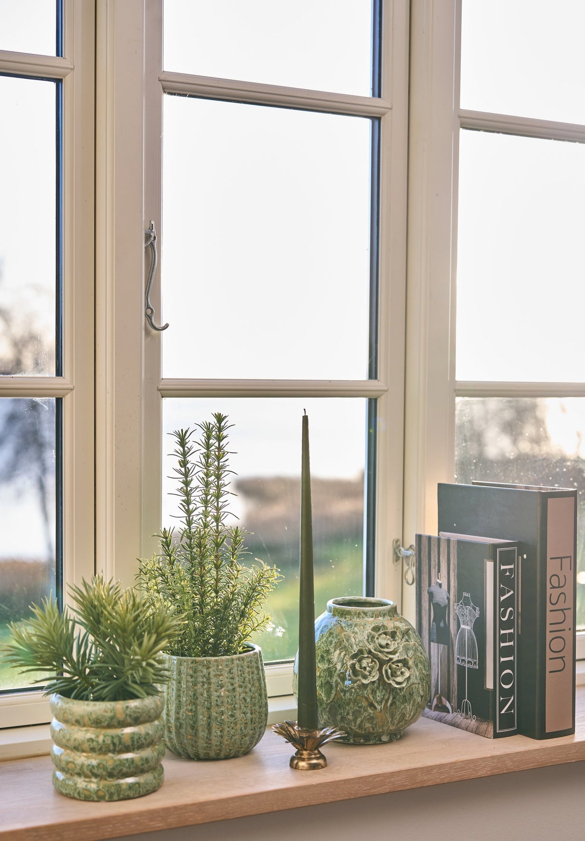 Antique gold leaf candlestick from Speedtsberg on a windowsill with succulents in pot covers