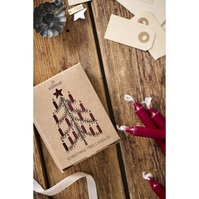 Dekorativ æske med røde juletræslys liggende på et bord