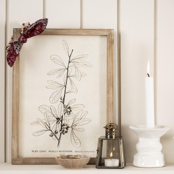 Ib Laursen guldfarvet mini lanterne 12 cm med blomstermønster foran tegning i træramme