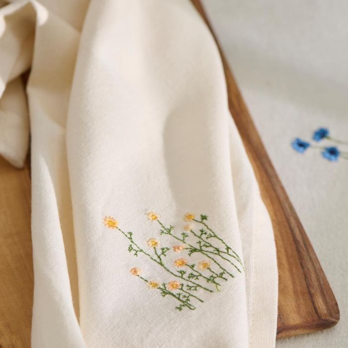 Ib Laursen Flora stofserviet med smørblomster ovenpå træbræt