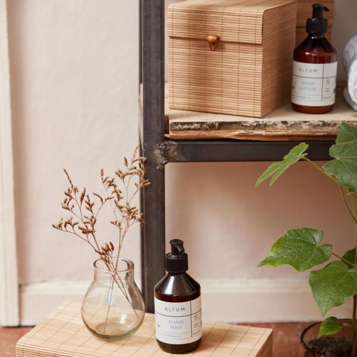 ALTUM Golden Grass håndsæbe 250 ml fra Ib Laursen på bambusmåtte med reol i baggrunden