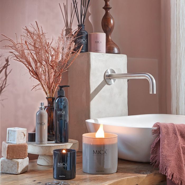 Mica Decorations duftlys wood fire i sort glas tændt ved siden af håndvask