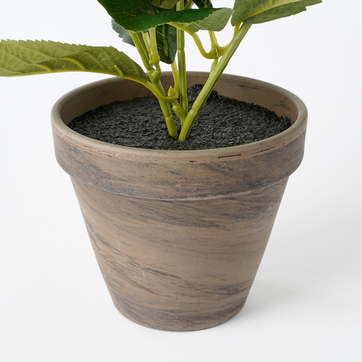 Grå potteskjuler med kunstig plante i
