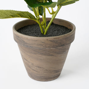 Grå potteskjuler med kunstig plante i
