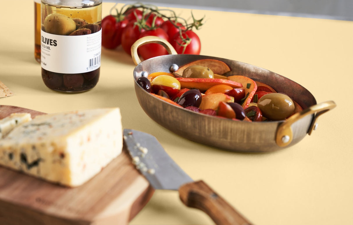 Smørebræt i akacietræ med ost på stående på bord med tapas