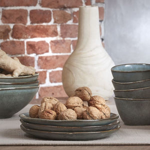 Tabo frokosttallerkener i grøn stentøj stablet med valnødder