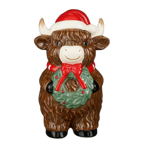 Cow wearing a Santa hat and a Christmas wreath