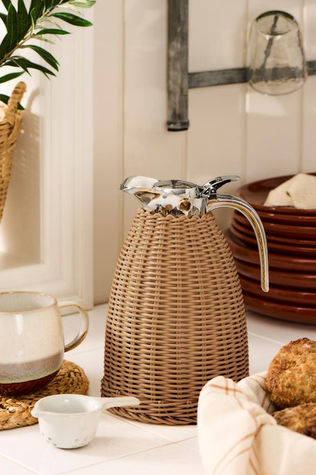 Brown hand-woven polyrattan insulated carafe from Ib Laursen on a kitchen countertop