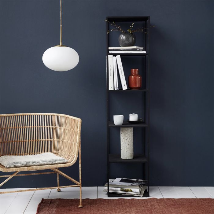 Hvid Opal pendel fra House Doctor med messingfinish over stol ved siden af reol