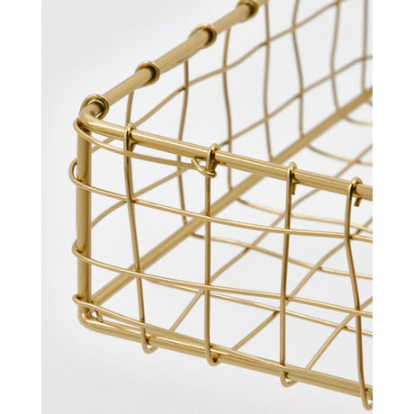Et hjørne af guldfarvet servietkurv i metal fra House Doctor