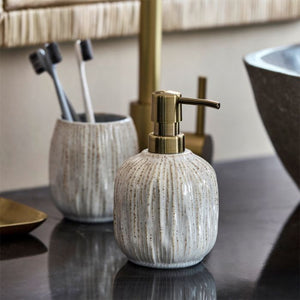 Sæbedispenser i råhvidt stentøj fra House Doctor sammen med tandbørstekrus i samme serie