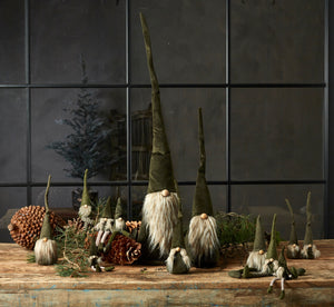 Christmas gnome figurines in green velour from Speedtsberg on a table with pine cones