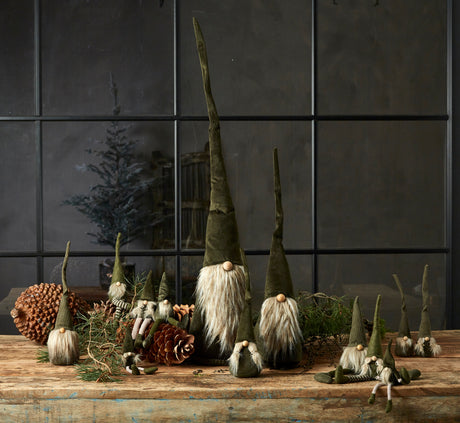 Family of green gnomes from Speedtsberg on a table with pine cones and moss