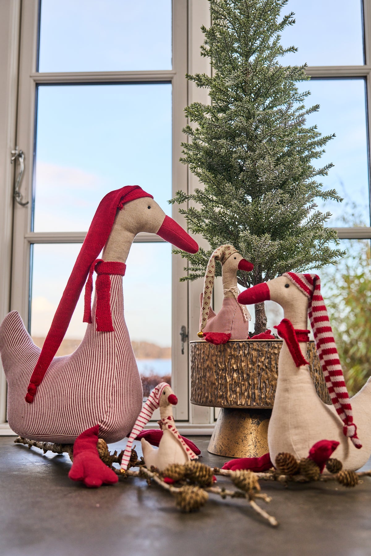 Speedtsberg geese on a windowsill with a fir tree in a gold stand
