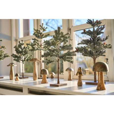 Svamp med sølvfarvet hat som dekoration i vindueskarm.