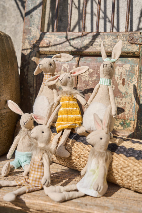 Kaniner i stof nyder solskinnet på en trappe