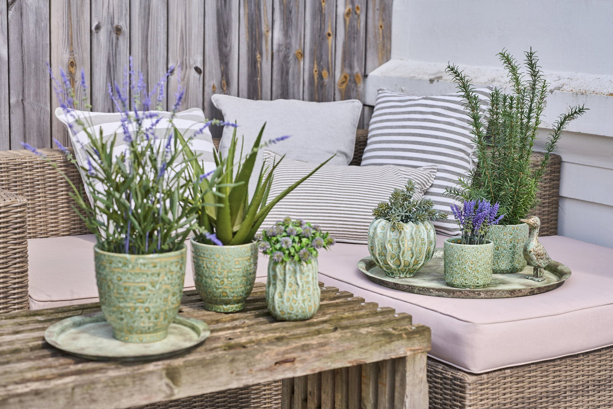 Antique green decorative tray from Speedtsberg with flowers and green plants in a summery arrangement on a wooden table