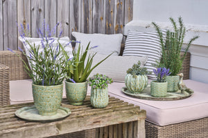Antique green decorative tray from Speedtsberg with flowers and green plants in a summery arrangement on a wooden table