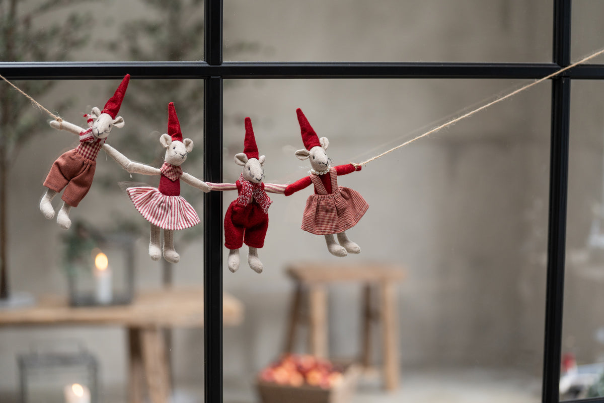 Noa and Nelli Christmas mice arranged as a garland in front of a window