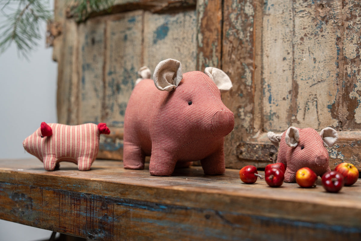 Adorable Christmas pig ornaments decorating a shelf with apples