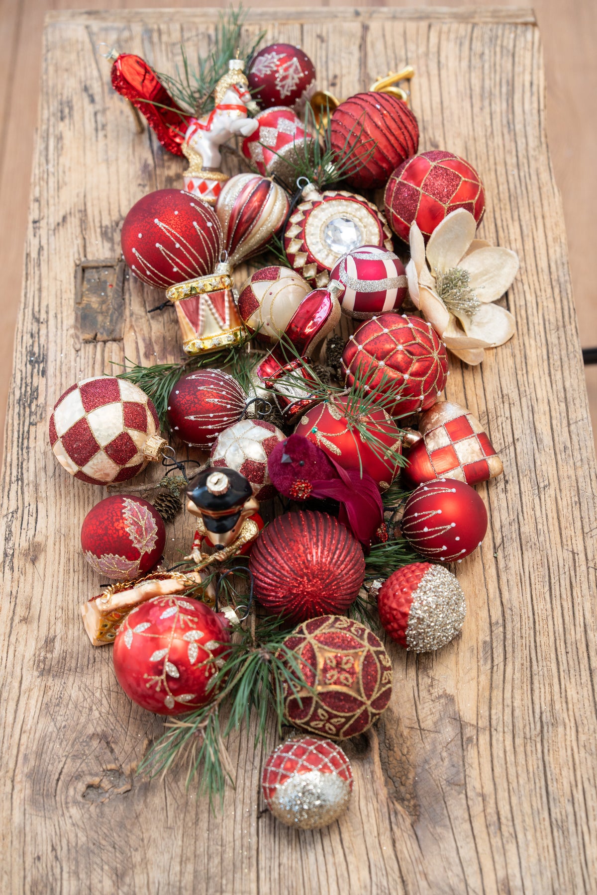 Glass Christmas baubles in shades of red, arranged as a table centerpiece