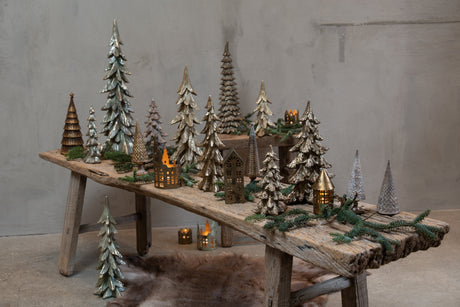 Christmas display with spruce trees and illuminated houses from Speedtsberg on a wooden bench