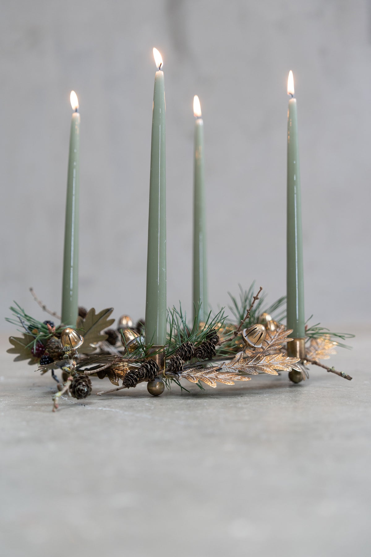 Advent centerpiece with acorns and leaves in an antique gold finish from Speedtsberg, decorated with silk fir and dusty green advent candles