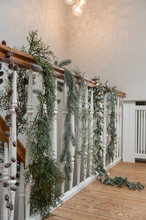 Various artificial garlands draped over a stair railing