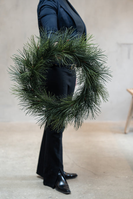 Silk fir wreath, 60 cm diameter, from Speedtsberg, shown in front of a human figure