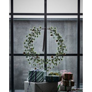 Krans med kogler som vinduesdekoration