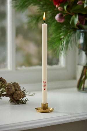 Taper candle with "Merry Christmas" text set in a brushed brass candlestick from Ib Laursen