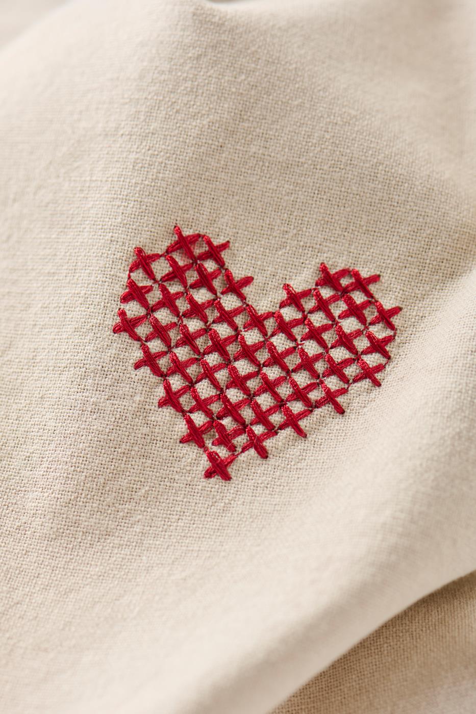 Traditional fabric napkin with a red cross-stitched heart from Ib Laursen
