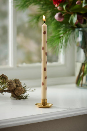 Tea light candles with brown pine cones in a gold-colored candle holder from Ib Laursen