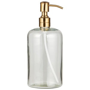 Clear glass soap dispenser by Ib Laursen with a brass-colored stainless steel pump head