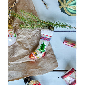 House Doctor Christmas ornaments laid out on a table with fir branches and tissue paper