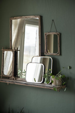 Assorted Ib Laursen mirrors on a wall shelf