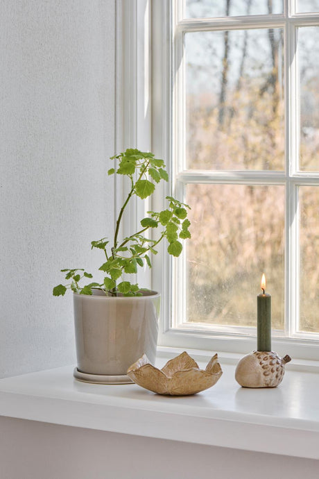 Leaf-shaped stoneware bowl with a rustic finish from Ib Laursen on a windowsill