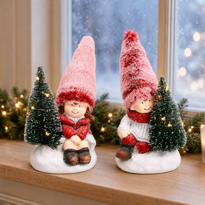 Winter children with Christmas trees in the snow