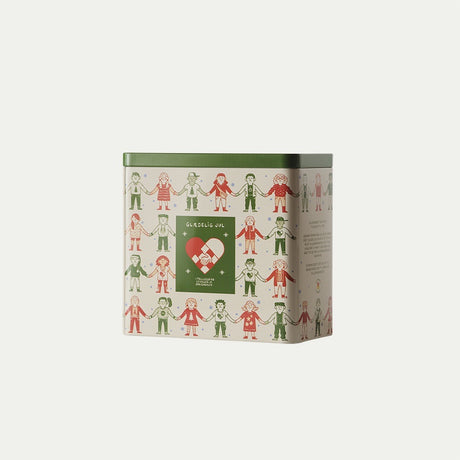 Cookie tin with the Christmas Seal 2026 featuring colorful children, a red Christmas heart, and a green lid