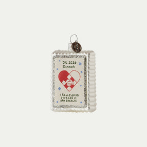 Christmas seal ornament 2026 with woven Christmas heart, hands holding each other, and a silver glitter edge