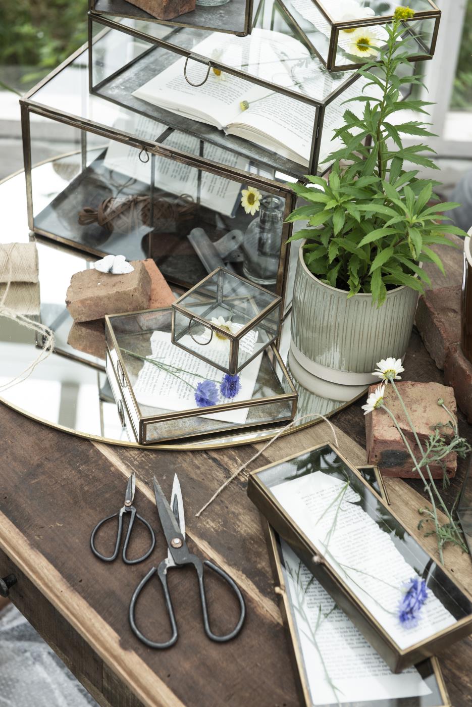 Open Solitaire glass box from Ib Laursen on a work table with small items and craft materials