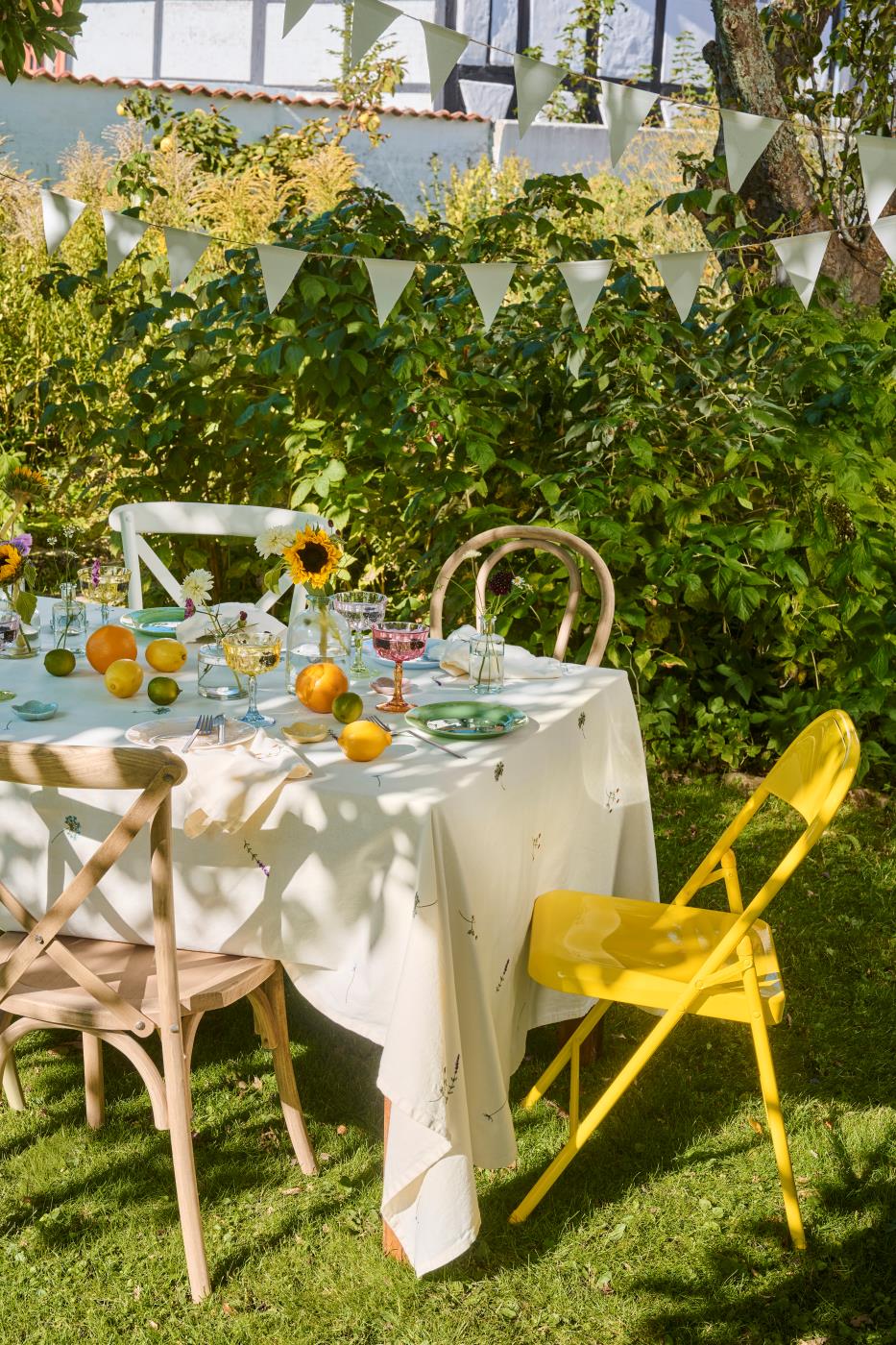 Dækket bord i haven med dug fra Ib Laursen med broderede blomster